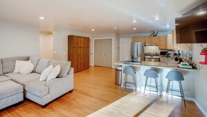 A modern kitchen with a central island, bar stools, and wooden cabinets. - Ski & Board in South Lake Tahoe! Updated Home (South Lake Tahoe)
