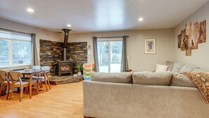 A cozy living room with a fireplace, a sofa, and a dining area with chairs. - Ski & Board in South Lake Tahoe! Updated Home (South Lake Tahoe)