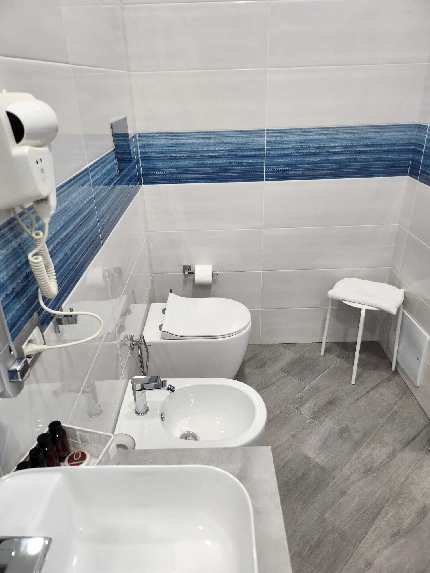 A bathroom with a toilet, bidet, and sink.