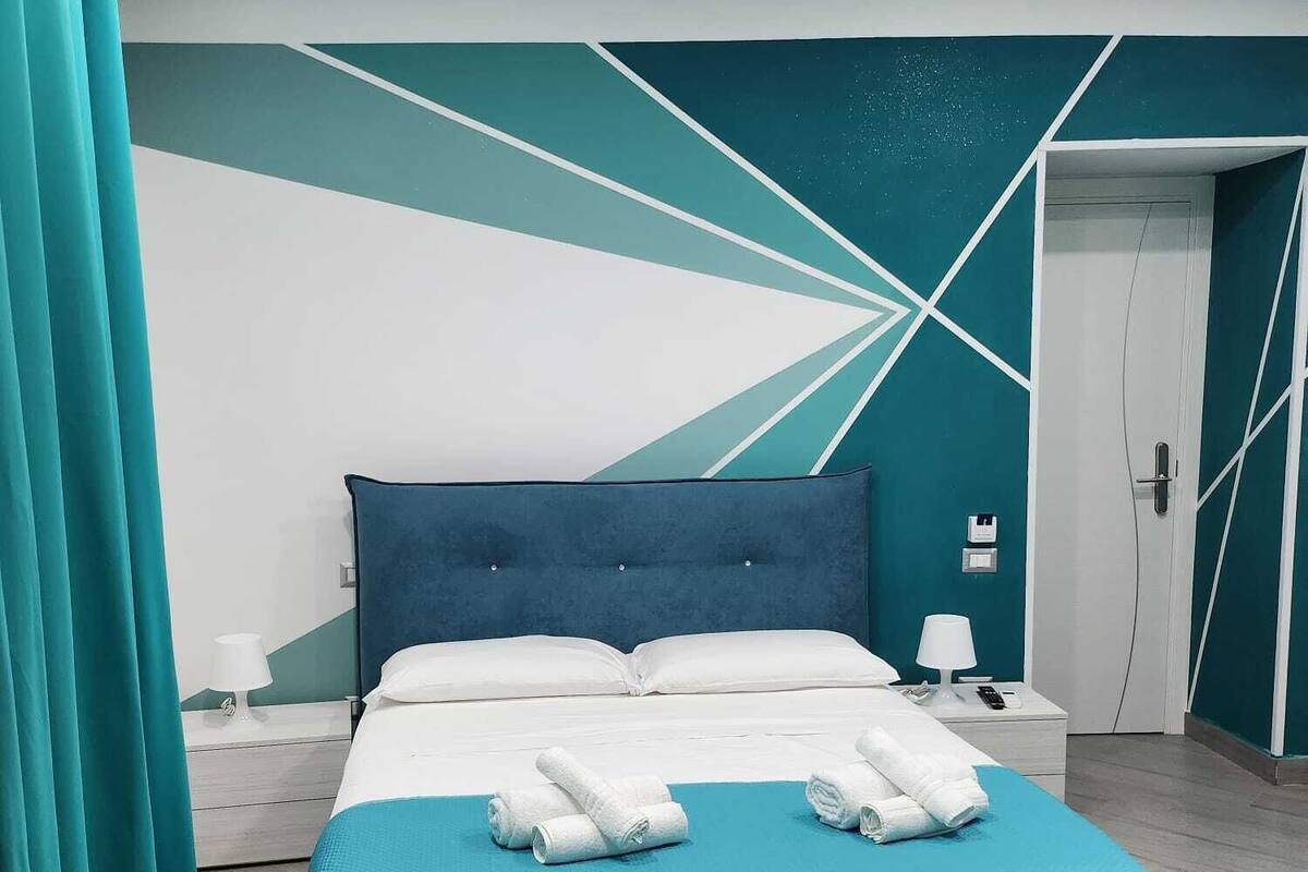 Un dormitorio moderno con una cama grande, una mesita de noche y una puerta.