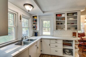 A kitchen with white cabinetry, a double sink, and a built-in pantry with shelves. - Near Beach: Coastal Maine Getaway w/ Yard (Wells)