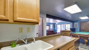 A kitchen with wooden cabinets, a white sink, and a green soap dispenser. - Peaceful Pinetop-lakeside Suite w/ Fire Pit! (Lakeside)