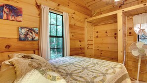 A wooden cabin bedroom with a bed, a window, and a fan. - Hendersonville Cabin Near Hiking & Waterfalls! (Hendersonville)