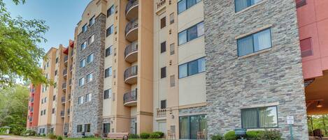 A multi-story building with balconies, a patio area with a bench, and a 'No Parking' sign.