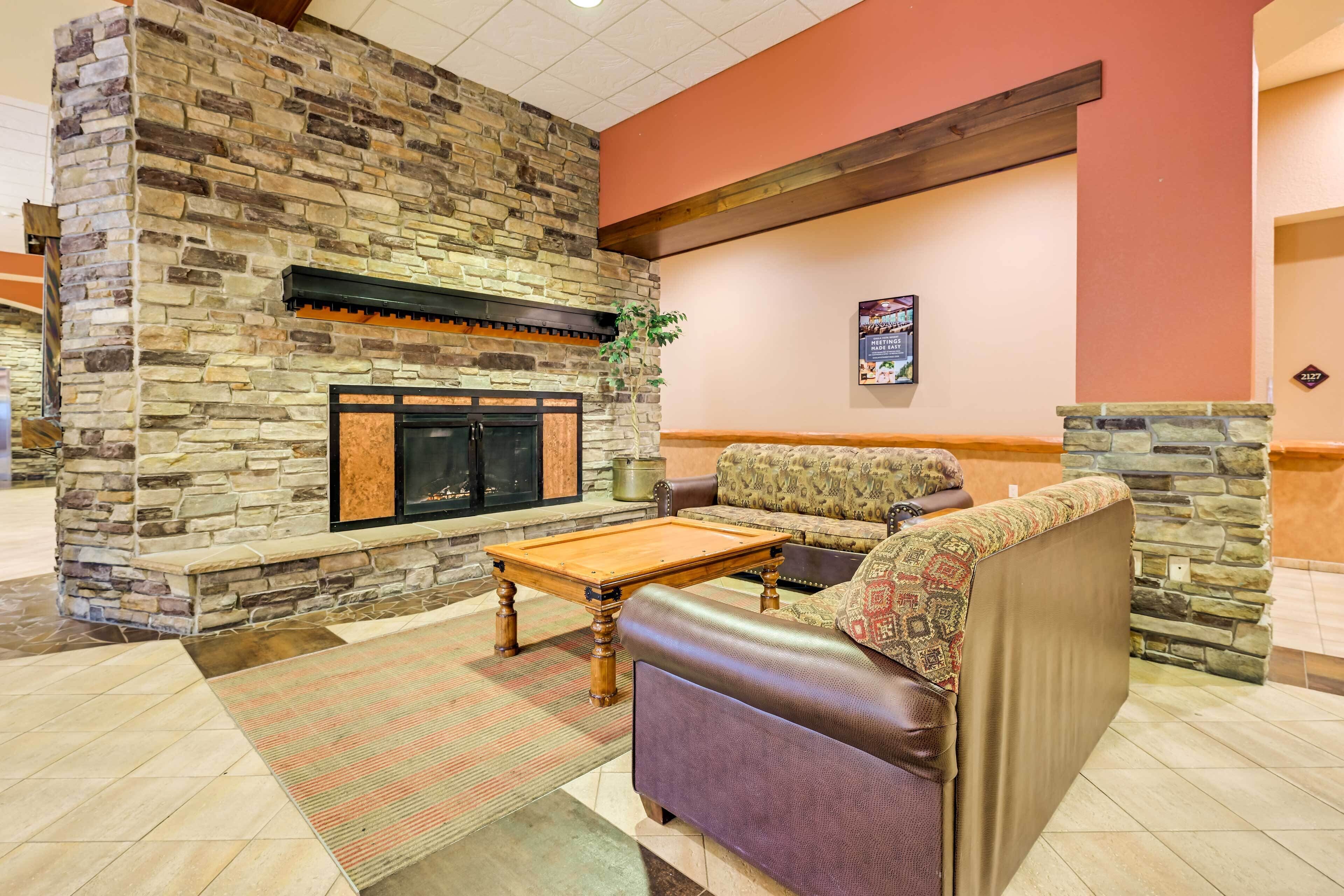 A lobby with a stone fireplace, a sofa, and a coffee table.