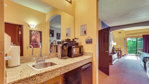 A hotel bathroom with a sink, mirror, and towel dispenser. There is a coffee maker and a microwave on the countertop. - Wisconsin Dells Resort Condo w/ Star Wars Decor! (Wisconsin Dells)
