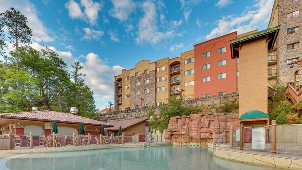A hotel with a pool area, multiple balconies, and a mountainous backdrop. - Wisconsin Dells Resort Condo w/ Star Wars Decor! (Wisconsin Dells)