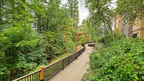 A pathway surrounded by lush greenery and a wooden pergola structure. - Wisconsin Dells Resort Condo w/ Star Wars Decor! (Wisconsin Dells)