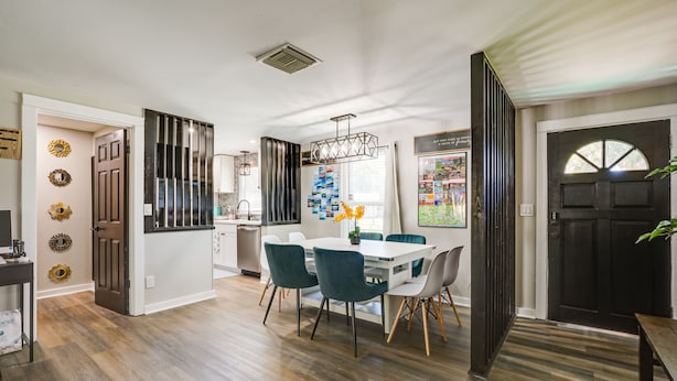 A modern kitchen with a white countertop, a built-in oven, and a stainless steel range hood.