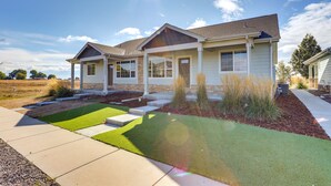 A two-story house with a front porch, a well-maintained lawn, and a clear sky. - Quiet Evans Home Rental Near Parks & Downtown! (Evans)