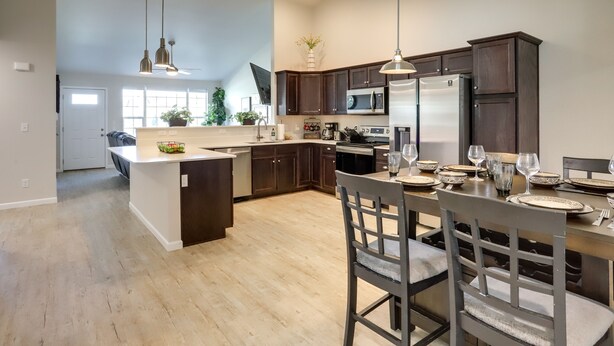 A modern kitchen with dark wood cabinets, stainless steel appliances, and a central island. - Quiet Evans Home Rental Near Parks & Downtown! (Evans)