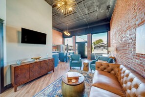Un salon moderne avec un canapé en cuir, une table basse en bois et un fauteuil bleu.