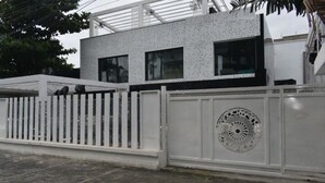 Un bâtiment moderne à la façade blanche, agrémenté d’une grille décorative en métal.