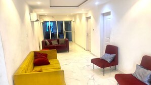 Un salon moderne avec un canapé jaune, un canapé rouge et un fauteuil rouge.