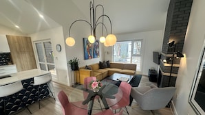 A modern kitchen with a dining area, a sofa, and a coffee table. - Location! New, Modern Townhouse Steps from 124 Street! (Edmonton)