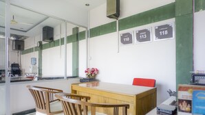 Une salle de conférence avec une table et des chaises en bois, un vase rempli de fleurs et des panneaux numérotés accrochés au mur.