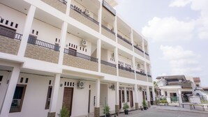 Un immeuble à plusieurs étages doté de balcons, de climatiseurs et d’une enseigne indiquant « OYO LIFE ».