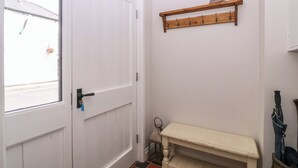 A hallway with a white door, a bench, a coat rack, and a window with a view of the street. - 19 Lion Street (Hereford)