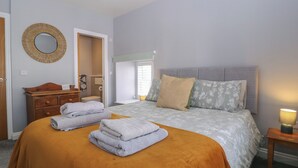 A bedroom with a bed, a dresser, a mirror, and a bedside lamp. - 19 Lion Street (Hereford)