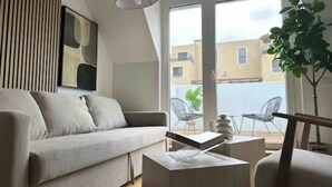 Un salon moderne avec un canapé, une table basse et une plante en pot.