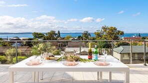 Outdoor dining - Coastal Breezes – water views, swimming pool, walk to beach (Corlette)