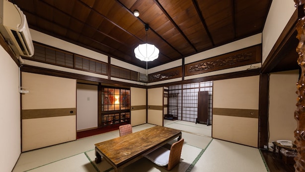 A traditional Japanese room with tatami flooring, a low wooden table, and sliding doors. - Hotel Sumire (Shimonoseki)