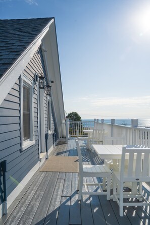 A deck with white railings, a table, and chairs.