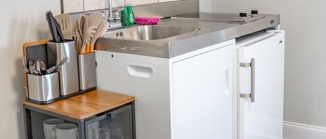 A compact kitchen with a microwave, stove, and sink.