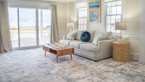 A living room with a sofa, a coffee table, and a side table with lamps. - 935 Ocean A Beachside Inn (Hampton)