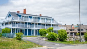 A two-story building with a blue exterior, multiple balconies, and a sign indicating it is a hotel. - 935 Ocean A Beachside Inn (Hampton)