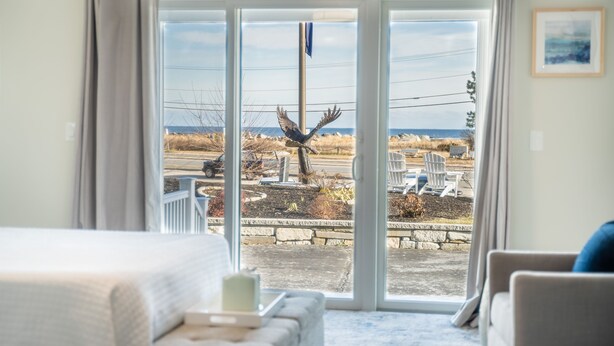 A room with a large sliding glass door leading to a patio area. - 935 Ocean A Beachside Inn (Hampton)