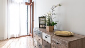 Un meuble en bois avec des tiroirs, une horloge, une plante en pot et un plateau.