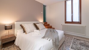 Une chambre à coucher avec un lit, une table de chevet et une fenêtre avec des rideaux.