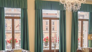 A spacious living room with a chandelier, two sofas, a coffee table, and a patterned rug. - Camera 1 - Grand Canal Suites by Wonderful Italy (Venecia)