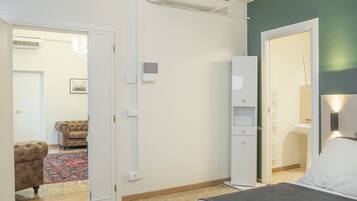 A bedroom with a bed, a wardrobe, a radiator, and a door leading to a bathroom.