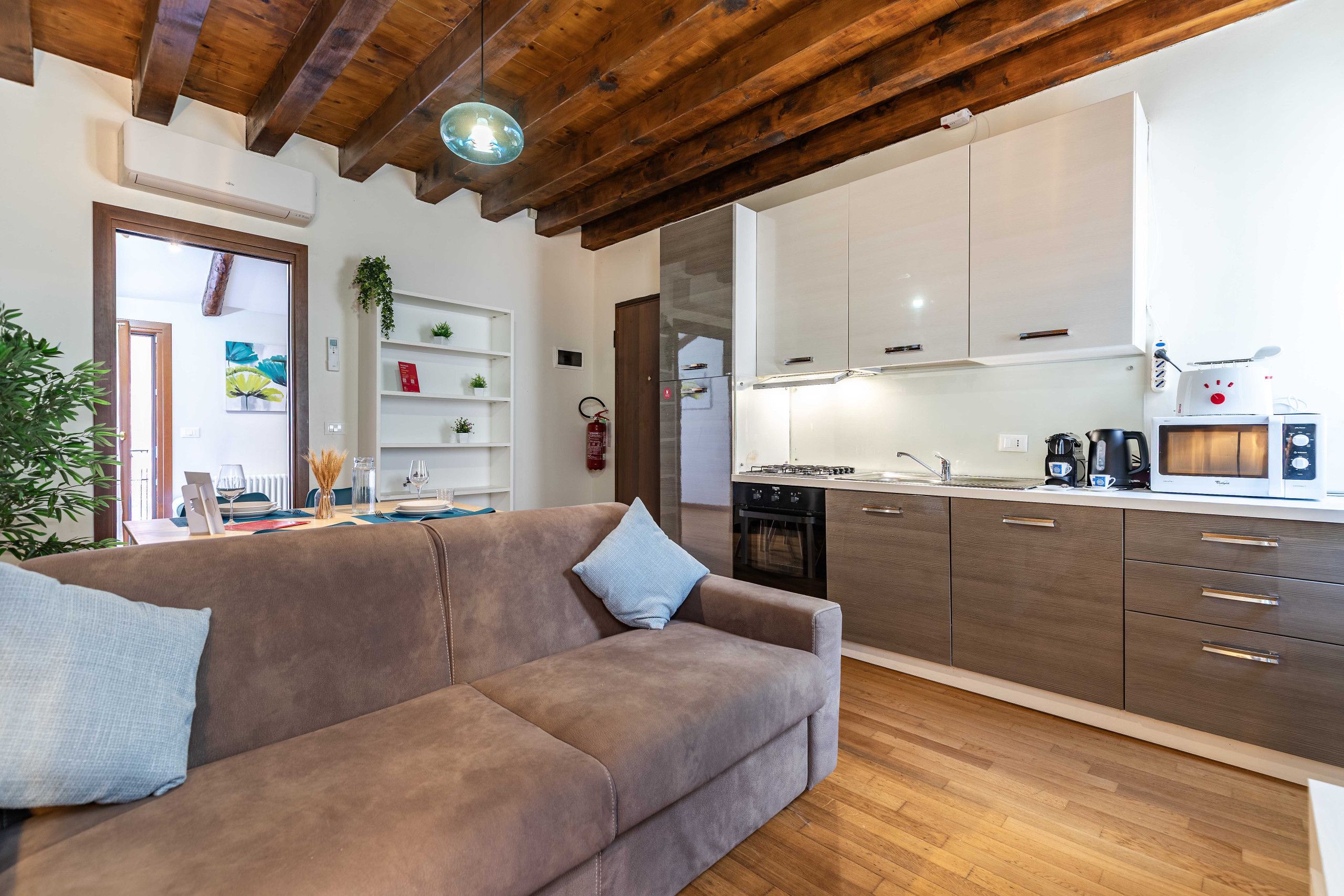 Una cucina moderna con mobili bianchi, forno integrato e microonde.