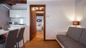 Eine moderne Küche mit weißen Schränken, einer Mikrowelle und einem Essbereich mit Tisch und Stühlen.