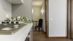Une cuisine avec un fourneau, une chaise et une table à l’arrière-plan.