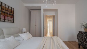 A bedroom with a bed, a wardrobe, a chandelier, and a view of the hallway. - San Marco Square With Terrace by Wonderful Italy (Venecia)
