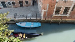 A canal with boats, a pedestrian walkway, and buildings with brick facades. - San Marco Style Canal View Apt. 2 by Wonderful Italy (Venecia)