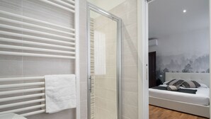 A modern bathroom with a glass shower enclosure, a white towel on the radiator, and a visible toilet. - San Marco Style Canal View Apt. 2 by Wonderful Italy (Venecia)