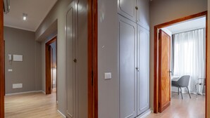 Une pièce spacieuse avec un plancher en bois, une grande armoire et un bureau avec une chaise.