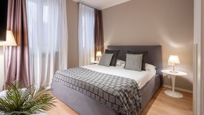 A neatly arranged bedroom with a large bed, two bedside tables with lamps, and sheer curtains. - San Marco Suite 2 by Wonderful Italy (Venecia)