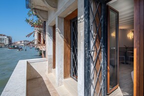 A waterfront hotel with a balcony overlooking a canal, a wooden door with a metal grille, and a dining area with modern lighting. - Stanza 1 - Venice View 2 by Wonderful Italy (Venecia)