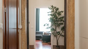 Ein Flur mit einer Holztür, einem Blumentopf und einer Lampe.