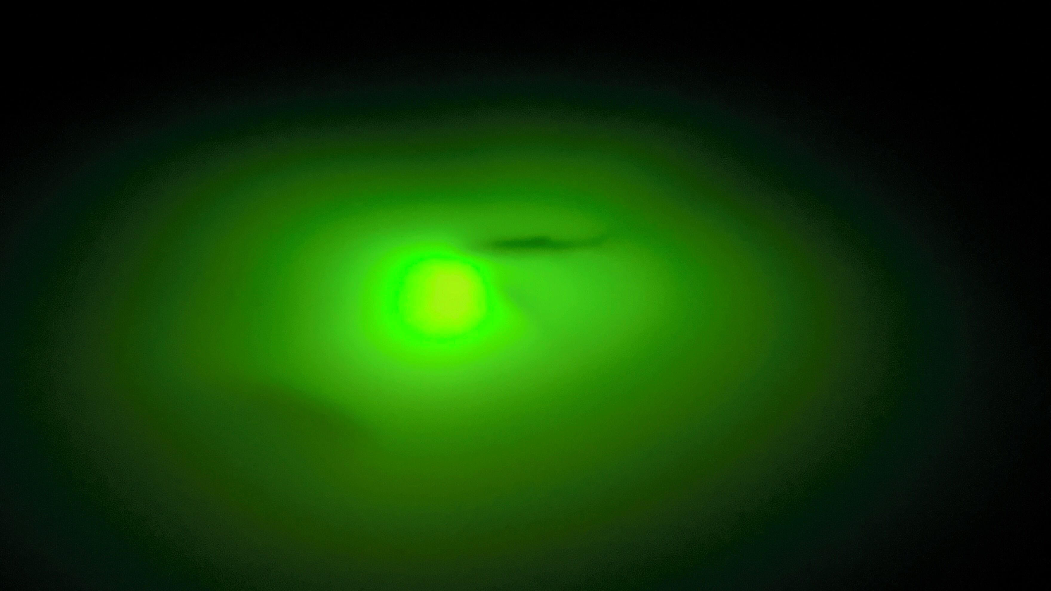 A green light source with a blurred central area.