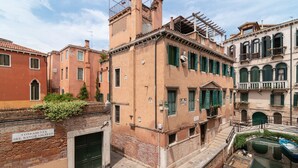 A historic building with a brick facade, green shutters, and a sign indicating it is the Foundation of the Bank of San Lio. - Venice Luxury Palace 3 by Wonderful Italy (Venecia)