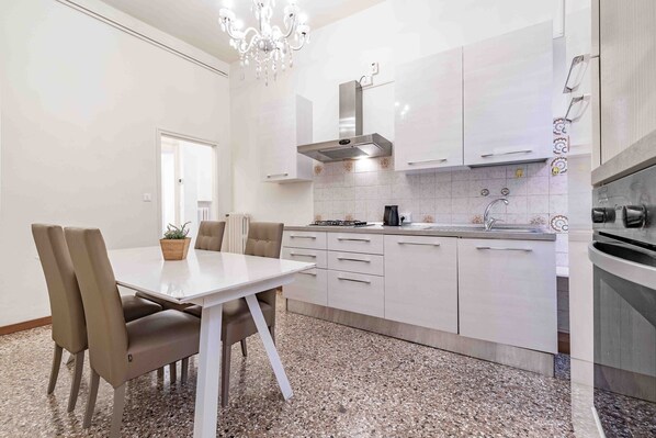 A modern kitchen with white cabinets, a gas stove, and a built-in oven.
