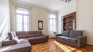 A living room with a sectional sofa, a smaller sofa, and a built-in bookshelf. - Venice Luxury Palace 6 by Wonderful Italy (Venecia)