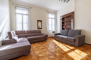 A living room with a sectional sofa, a smaller sofa, and a built-in bookshelf. - Venice Luxury Palace 6 by Wonderful Italy (Venecia)